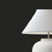 Surya Arion accent table lamp with a white linen shade and a textured, glazed cream ceramic base.
