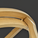 Close-up of a light brown wooden chair back with a curved top rail and visible joinery.