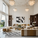 Two Surya Aasmaa AAM-001 modern black and white abstract wall art pieces, 21" x 19", above brown leather chaises.