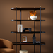 Modern white ceramic vase-style accent on a black shelf with other decor.