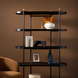 Modern white ceramic vase-style accent on a black shelf with other decor.
