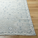 Hand-knotted Surya Almeria ALM2302 low pile rug in multi-tone denim, black, dusty sage, and cream with fringe.