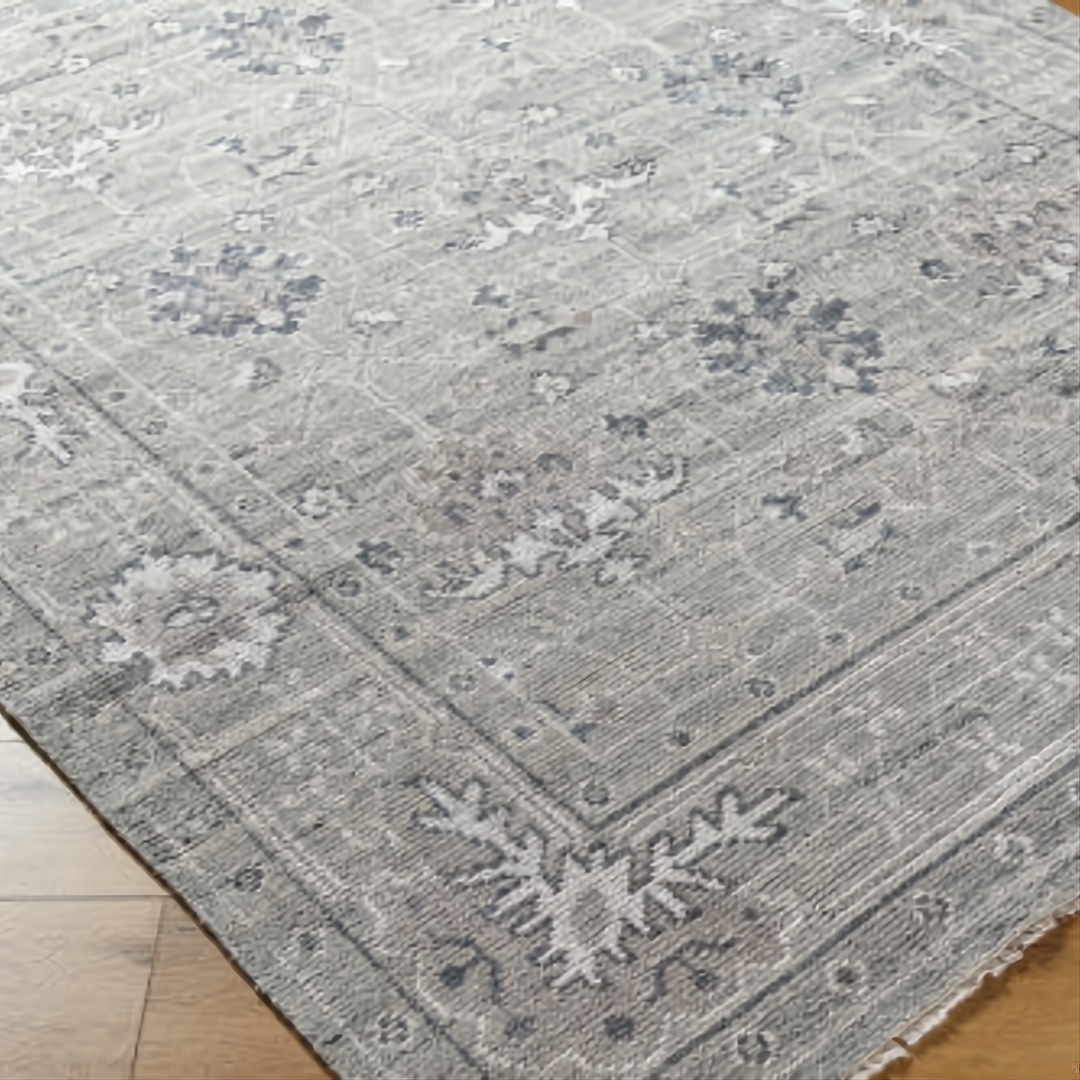 Surya Almeria low pile area rug in medium gray, gray, and cream with a refined floral pattern.