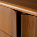 Close-up of Grande Collection brown stained poplar dresser with minimalist modern design and curved drawer fronts.
