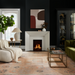 Surya Capelli accent table lamp with a white ceramic base and fabric shade in a dark living room.