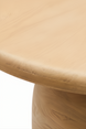 Beige round mango wood dining table with a brushed finish, showcasing the natural wood grain.