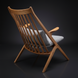 Mid-century modern wooden accent chair with slatted back and gray upholstered cushions.