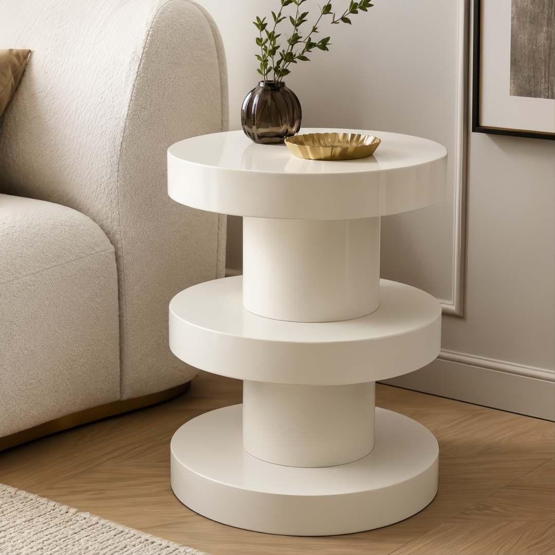 Cream iron Surya Roth End Table with tiered shelves and a high gloss finish, styled beside a sofa.
