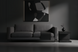 Surya Coburn black mango wood end table next to a gray sofa in a minimalist room.