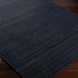 Surya Hickory HCK2300 area rug in dark charcoal, black, and gray with subtle textured patterning on a wood floor.