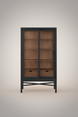 Tall black and brown Marin bookcase with glass sliding doors, adjustable shelves, and two soft-close drawers.