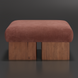Surya Mirava Ottoman with a rectangular, upholstered rust-colored polyester top and two wooden block legs.
