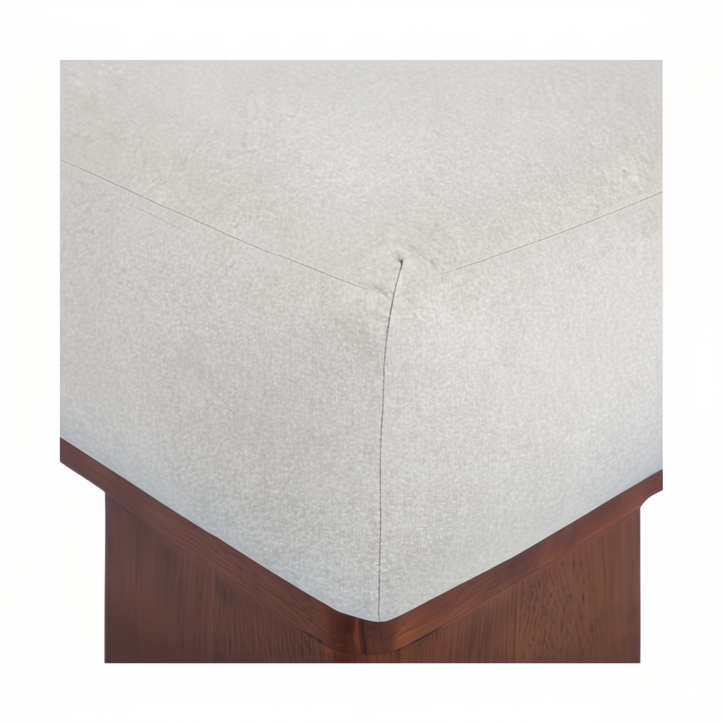 Close-up of a square ottoman with a light beige polyester top and a dark brown rubber wood base.