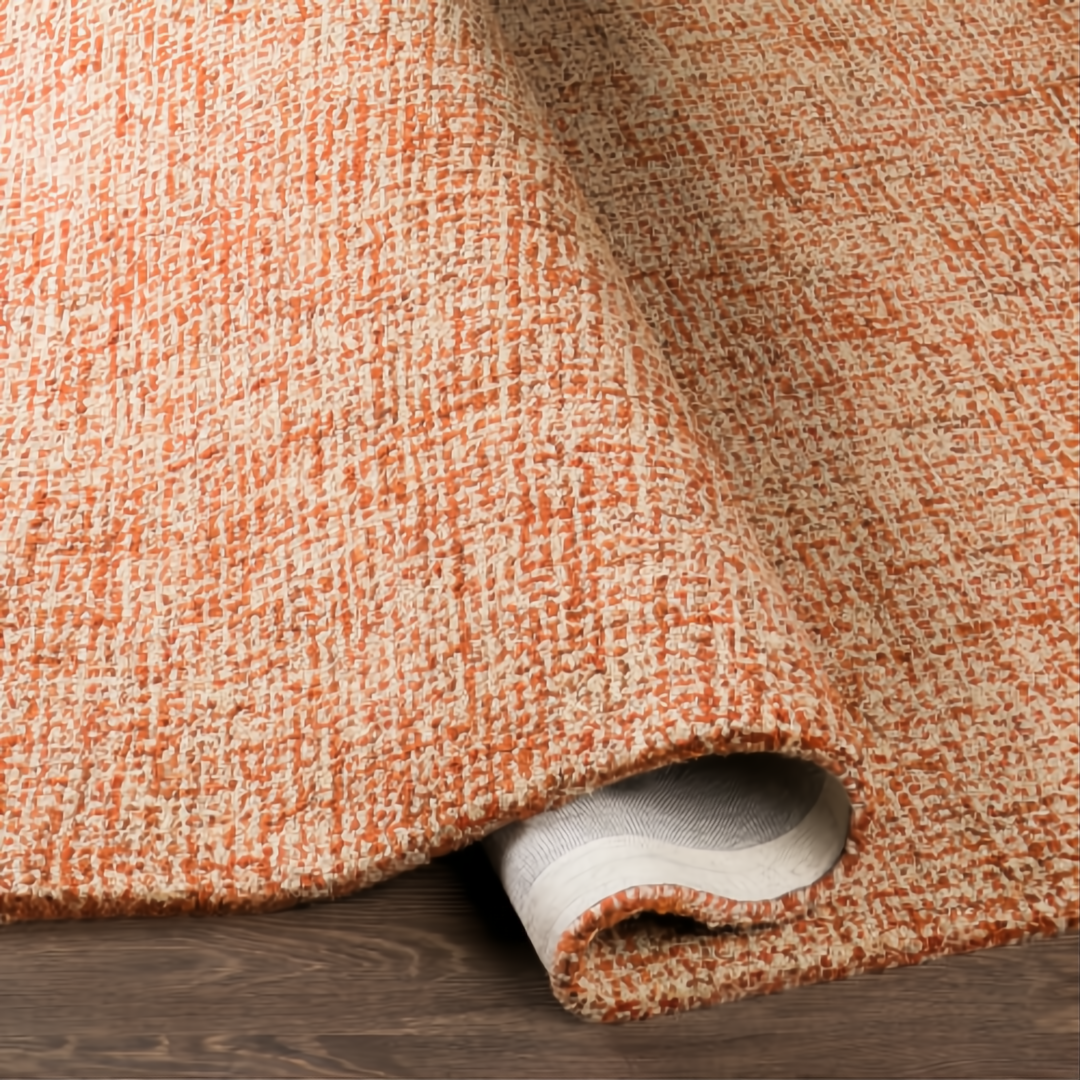 Surya Aiden AEN-1003 hand-tufted wool rug in burnt orange and ivory, partially rolled on a wood floor.