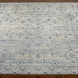 Surya Almeria hand-knotted low pile area rug in multi-tone denim, black, dusty sage, light beige, cream, and burgundy.
