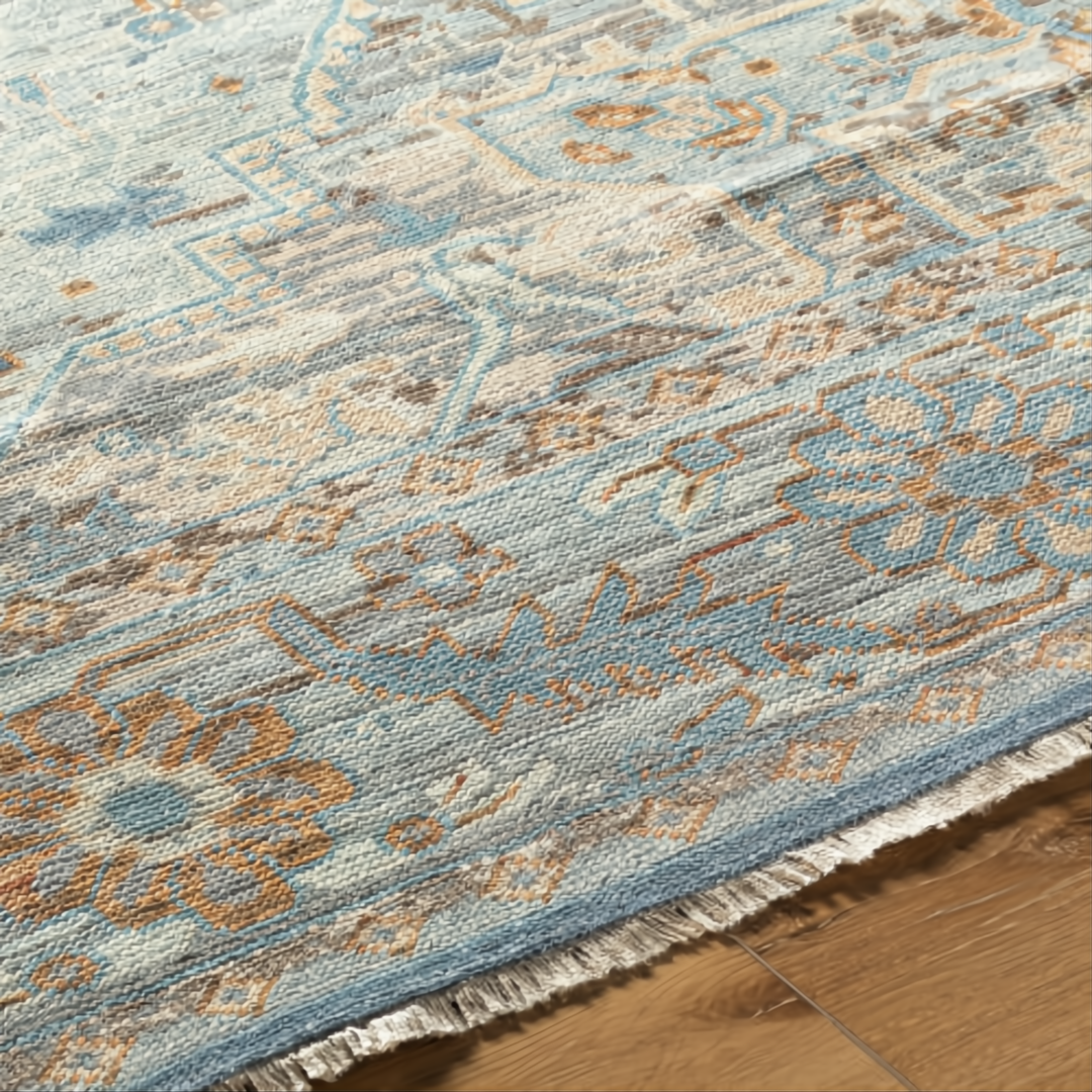 Surya Cappadocia hand-knotted wool rug with traditional pattern in pale blue, gray, taupe, and brown tones, featuring fringe.
