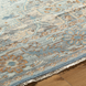 Surya Cappadocia hand-knotted wool rug with traditional pattern in pale blue, gray, taupe, and brown tones, featuring fringe.