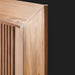 Close-up of a light brown lacquered mango wood cabinet with vertical fluted details on the door.