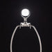 Silver metal lamp harp with a clear glass finial against a dark background.