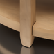 Close-up of Surya Rosemary end table leg and shelf, showing natural mango wood finish.