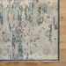 Hand-knotted wool area rug with traditional charcoal, wheat, and taupe design, low pile, and fringe detail.