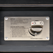 Close-up of a black hand-painted aluminum fire table's silver control panel with lighting instructions and an "OFF" to "HI" knob.