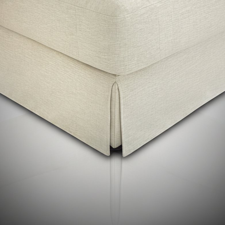 Close-up of a taupe Surya Elenora modular chair, showing its polyester upholstery and pleated skirt detail.