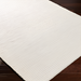 Surya Azalea AZA-2325 hand-woven, off-white recycled PET yarn area rug with subtle ribbed texture on dark wood floor.