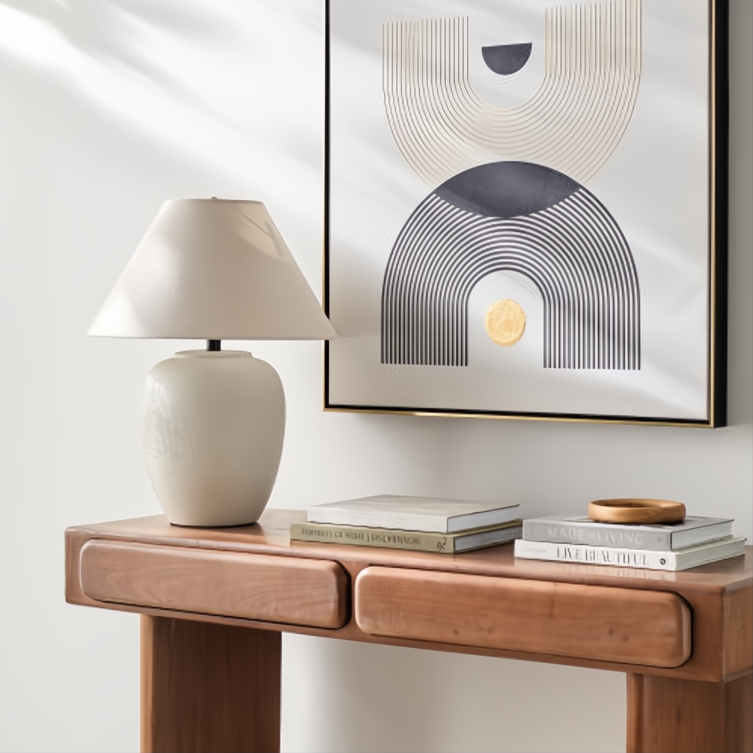 Surya Capelli accent table lamp with a cream ceramic base and fabric shade on a wooden console.