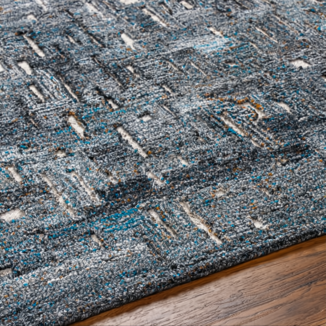 Surya Calgary CGR-2305-P hand-tufted rug with teal, charcoal, and gray abstract pattern on wood floor.