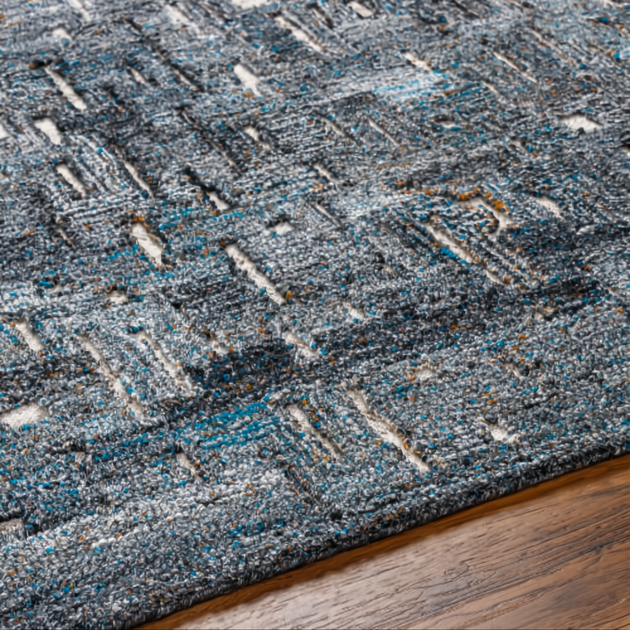 Surya Calgary CGR-2305-P hand-tufted rug with teal, charcoal, and gray abstract pattern on wood floor.