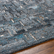 Surya Calgary CGR-2305-P hand-tufted rug with teal, charcoal, and gray abstract pattern on wood floor.