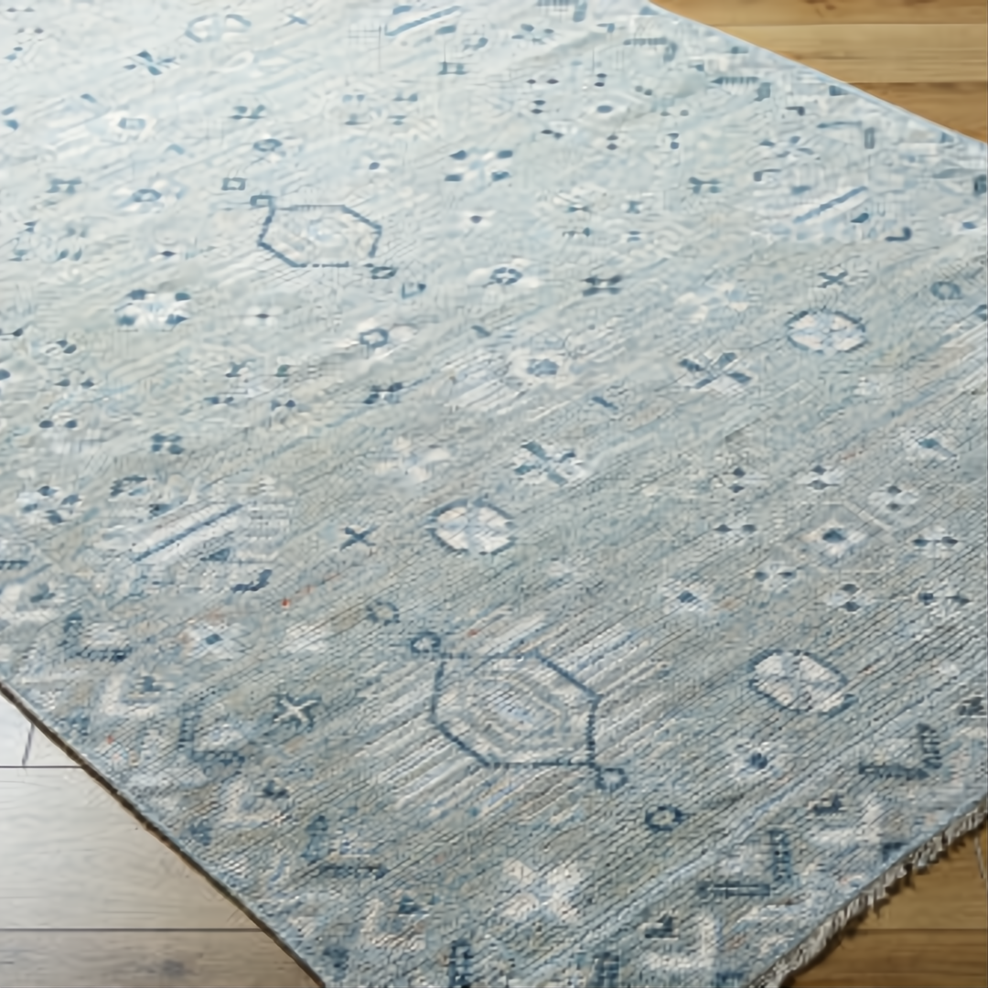 Surya Almeria low pile hand-knotted rug in multi-tone denim, black, dusty sage, light beige, cream, and burgundy.