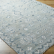 Surya Almeria low pile hand-knotted rug in multi-tone denim, black, dusty sage, light beige, cream, and burgundy.