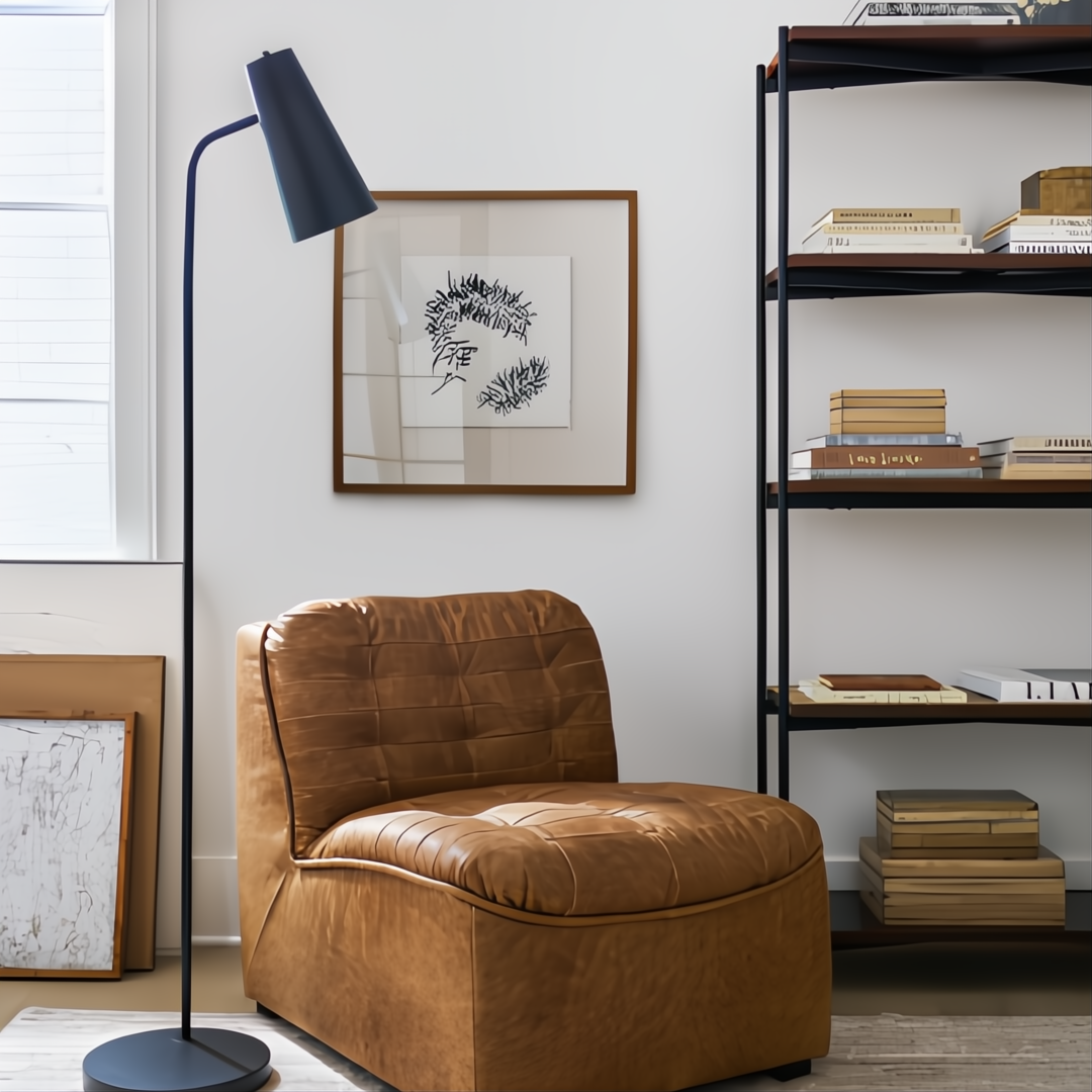 Brown leather modular chair with knife-edge design, black base, next to a black floor lamp and bookshelf.