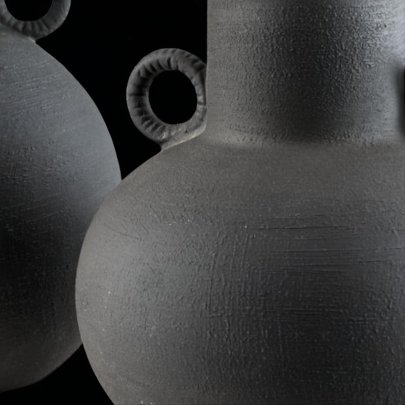 Dark grey ceramic decorative accent set with sculptural vase-like forms and textured finish.