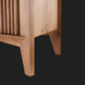 Close-up of the Surya Ronan Cabinet's brown lacquered mango wood, showing slatted door and tapered legs.