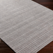 Surya Hickory HCK2304 area rug, hand-loomed from recycled PET yarn, featuring a subtle striped pattern in beige and gray.