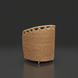 Woven light brown rattan dining chair with a curved back and decorative top edge, on a dark background.