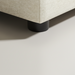 Close-up of a Surya Elenora modular chair's taupe polyester upholstery and black cylindrical leg.