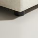 Close-up of a Surya Elenora modular chair's taupe polyester upholstery and black cylindrical leg.