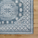 Surya Almeria low pile area rug in blue, white, and beige with geometric patterns and fringe.