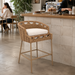 Surya Marvella counter stool in dark brown rattan with a light cushion, suitable for indoor/outdoor use.