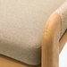 Close-up of Surya Palma Bench with beige Sunbrella upholstery, teak wood arm, and woven accent.