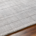 Surya Fresno FNO2302 hand-loomed rug, multi-tone gray recycled PET yarn, low pile, on wood floor.