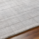 Surya Fresno FNO2302 hand-loomed rug, multi-tone gray recycled PET yarn, low pile, on wood floor.