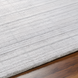 Surya Fresno FNO-2303-P area rug, light gray recycled PET yarn, hand-loomed, low pile, on wood floor.