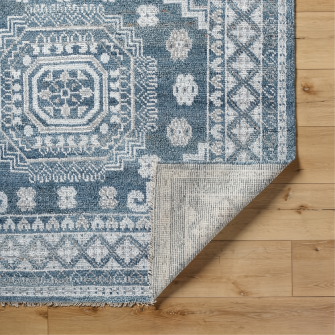 Hand-knotted Surya Almeria low pile rug in blue, gray, and cream with geometric patterns.