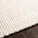 Surya Azalea AZA-2325 hand-woven ivory recycled PET yarn rug with ribbed texture on wood floor.