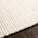 Surya Azalea AZA-2325 hand-woven ivory recycled PET yarn rug with ribbed texture on wood floor.